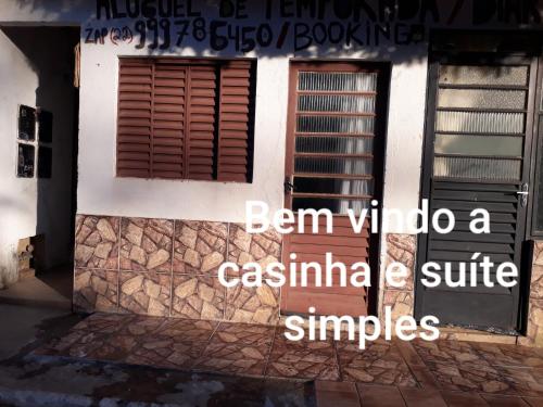 Antônio Prado的住宿－Casinhas no Interior de MG，一座房子,有一扇门和一扇窗户,上面写着风字,估计