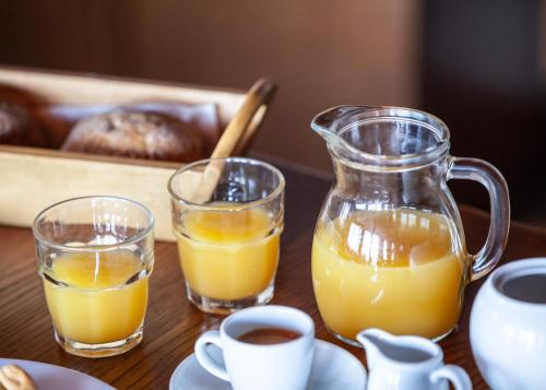 two glasses of orange juice and a jug of orange juice at Arxontiko Agonari in Metamorfosi