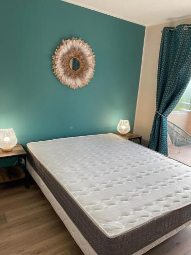 een bed in een kamer met een blauwe muur bij Appartement La Pensée in Mandelieu-la-Napoule