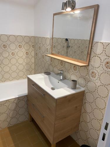 ein Bad mit einem Waschbecken und einem Spiegel in der Unterkunft Appartement La Pensée in Mandelieu-la-Napoule