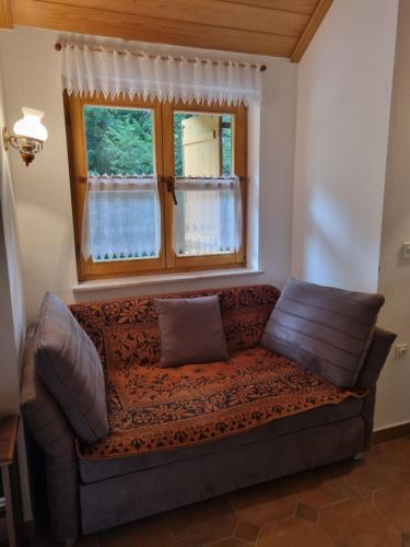 a couch in a living room with a window at Cottage by the pond Pavel in Šmarje pri Jelšah