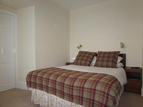 a bedroom with a bed and a dresser at The Haven Guest House in Plockton