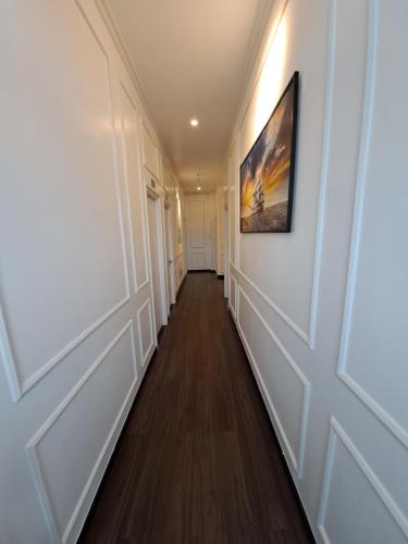 a hallway with white walls and a painting on the wall at Hotel My Cang in Trà Vinh