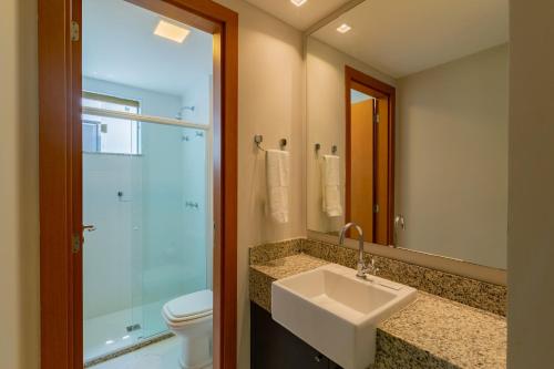 a bathroom with a sink and a toilet and a mirror at Ykutiba Imbassaí - Apartamento Superior - I104 in Imbassai