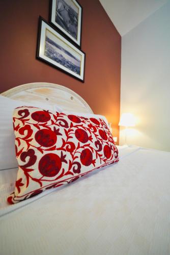 a bed with a red and white pillow on it at Kapya Cunda in Ayvalık
