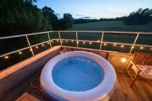 a jacuzzi tub on a deck with a view at Delightful 2 Bed Double Decker Bus with Hot Tub in Uckfield