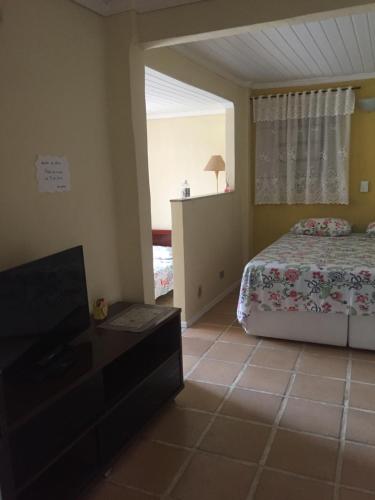 a bedroom with a bed and a flat screen tv at Apartamento Exclusivo in Campo Grande