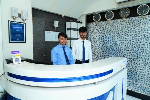 two men standing behind a counter in a room at Marshall The Hotel in Ahmedabad