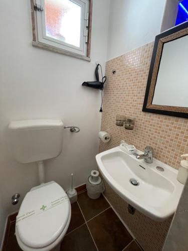 a bathroom with a toilet and a sink and a mirror at B&B Le Volte 27 in Gravina in Puglia