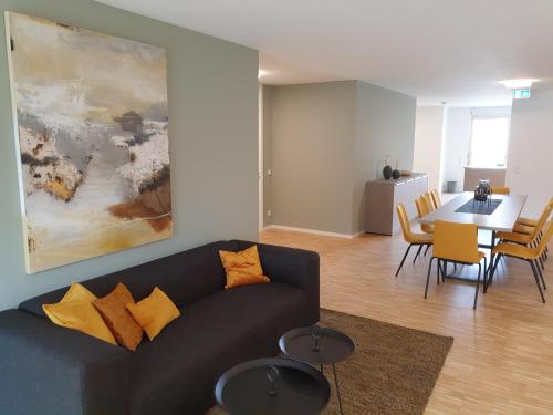 a living room with a couch and a dining room at Con4rent Business Hotel plus in Kirchheim unter Teck