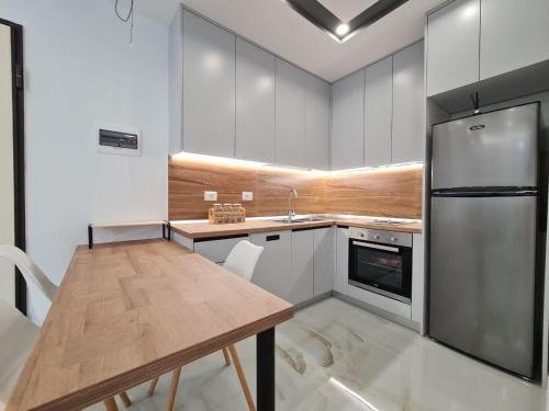 Il comprend une cuisine équipée d'une table en bois et d'un réfrigérateur. dans l'établissement Alvi apartment, à Golem