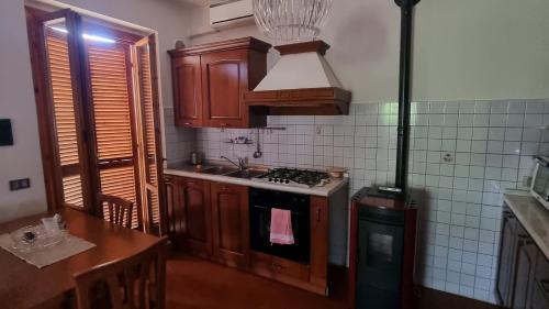 uma cozinha com armários de madeira e um forno com placa de fogão em Il Bagnolo em Palazzo