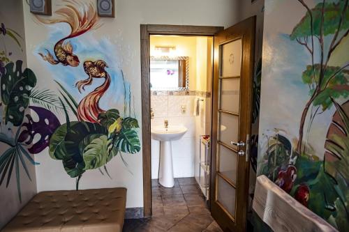 a bathroom with a painting on the wall and a sink at Villa ROYAL CLUB 13 in Jūrmala
