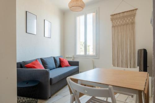 een woonkamer met een blauwe bank en een tafel bij Duplex, vue mer, proche du centre ville, 4P in Toulon