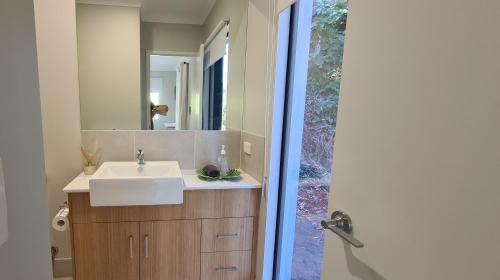 uma casa de banho com um lavatório e um espelho em Trinity Beach Escape em Trinity Beach