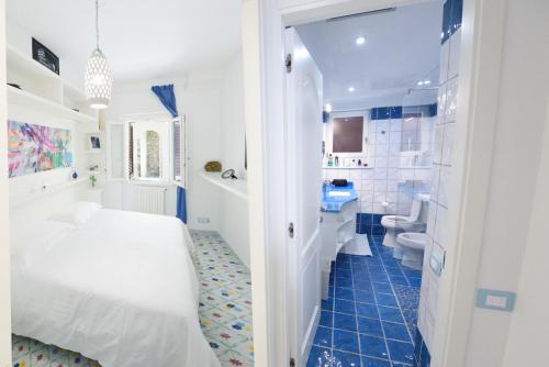 a bedroom with a white bed and a bathroom at Villa sul mare - Praiano (Amalfi Coast) in Praiano