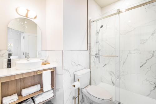 a bathroom with a shower and a toilet and a sink at Hôtel le Rosay in Venise-en-Québec