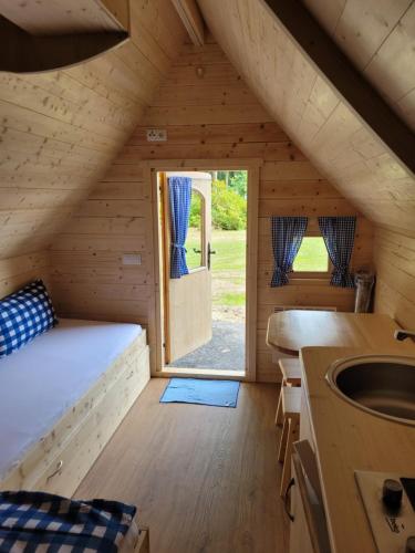 Zimmer mit einem Bett und einem Waschbecken in einer Hütte in der Unterkunft Gästehaus Bommelsen in Walsrode
