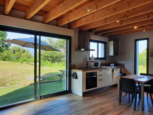 a kitchen and dining room with a table with an umbrella at Le Gîte d 'Emma en Vallée d'Ossau in Bescat