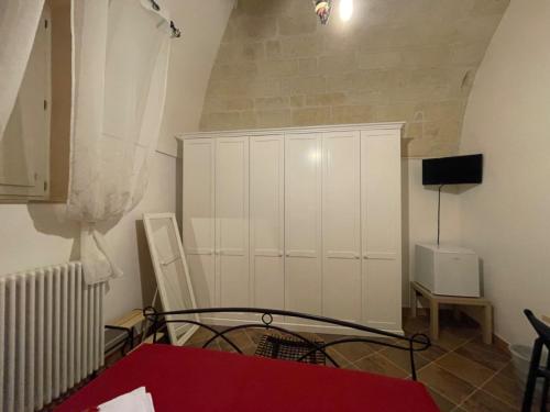a living room with a white cabinet and a red table at B&B Le Volte 27 in Gravina in Puglia