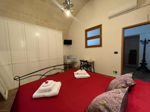a bedroom with a red bed with towels on it at B&B Le Volte 27 in Gravina in Puglia