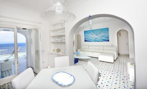 a living room with a white couch and a table at Villa sul mare - Praiano (Amalfi Coast) in Praiano