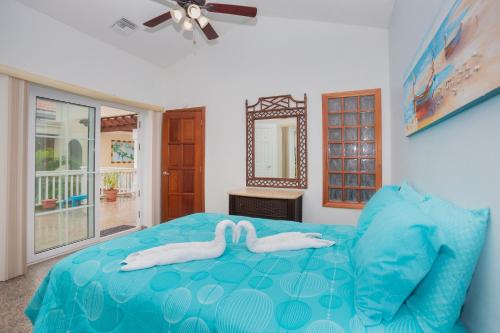 two white swans on a bed in a bedroom at Lawson Rock - Yellowfish 211 condo in Roatán