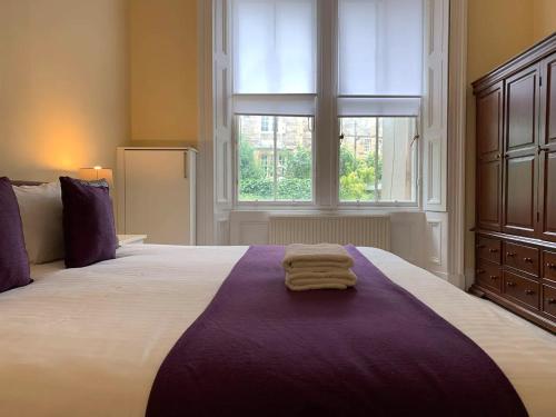 a bedroom with a large bed with two towels on it at ALTIDO Adorable flat near West End in Edinburgh