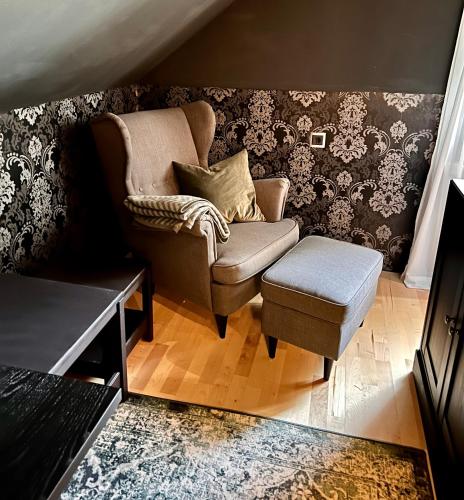 a living room with a chair and a stool at Luxus Ferienhaus Erzgebirge in Alleinlage in Kurort Altenberg