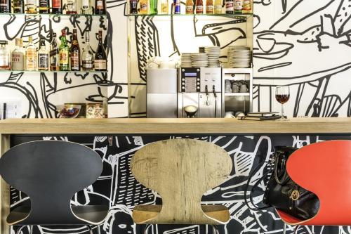 a room with a table and a guitar on a wall with graffiti at ibis Strasbourg Centre Historique in Strasbourg