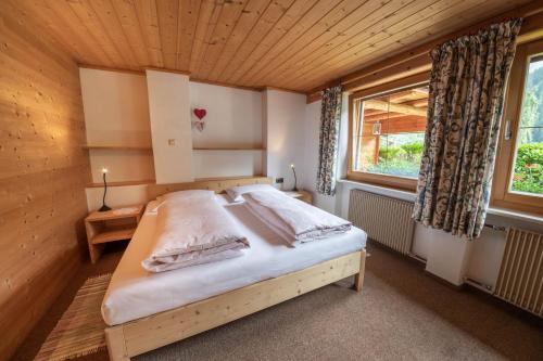 ein Schlafzimmer mit einem Bett in einem Holzzimmer in der Unterkunft Haus Adlerhorst in Ulten