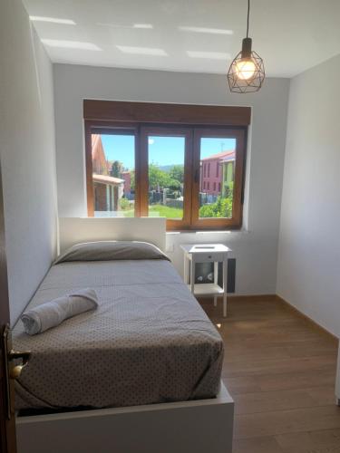a bedroom with a bed and a window at EL RINCON DE PARRES in Parres de Llanes