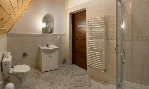 a bathroom with a toilet and a shower and a sink at NOCLEGI Grojec 