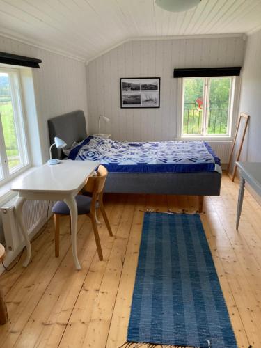 a bedroom with a bed and a desk and a table at B&B Bjärtrå in Hjälta