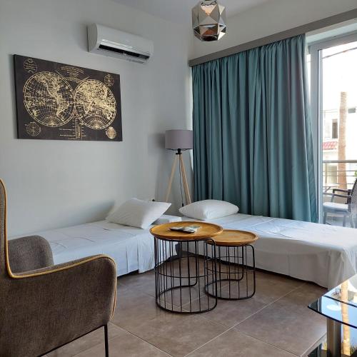 una camera d'albergo con due letti e un tavolo di Manolakis House a Kardámaina
