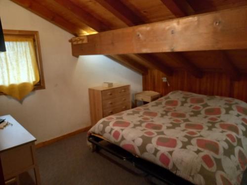 a bedroom with a bed and a wooden ceiling at Le Perce Neige d'Alicia in Sainte-Foy-Tarentaise