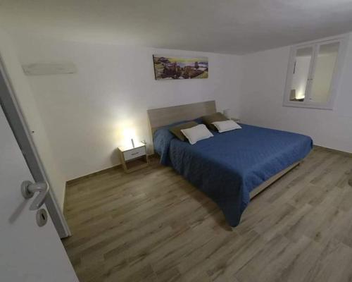 um quarto com uma cama azul e piso em madeira em Serendipity em Catânia
