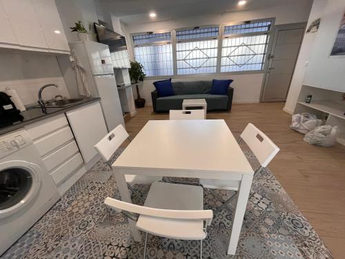 a kitchen and living room with a white table and chairs at Madrid River Dreams in Madrid