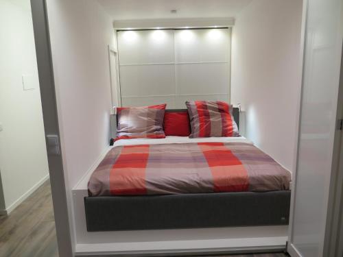 ein Schlafzimmer mit einem Bett mit roten Kissen in der Unterkunft Ferienpark Sierksdorf App 483 - Strandlage in Sierksdorf