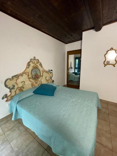 a bedroom with a bed with a blue comforter at Camera graziosa in Albinia