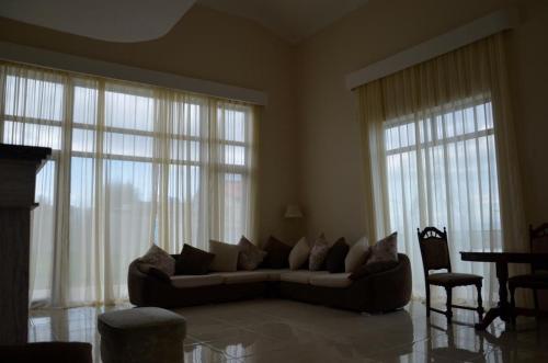 a living room with a couch and some windows at ILIANNO in Tabakhmela