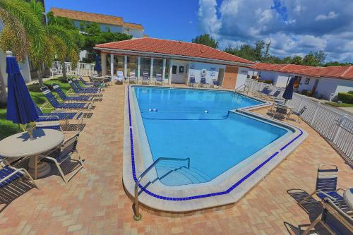 a large swimming pool with chairs and a table at Updated Condo with Pool, Walk to Crescent Beach & Restaurants! in Sarasota