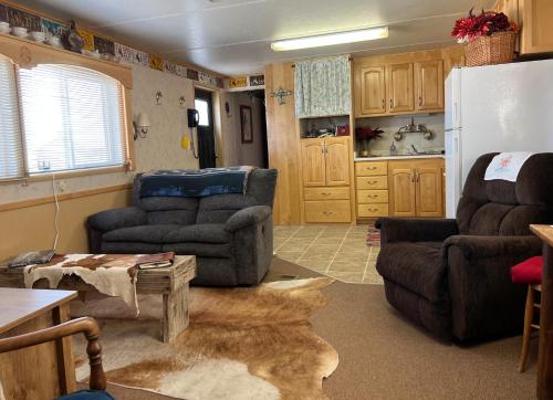 ein Wohnzimmer mit 2 Stühlen und einem Kühlschrank in der Unterkunft JMA Bunkhouse in Riverton