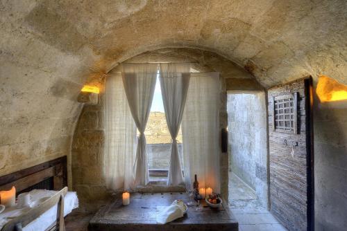 a bathroom with a window with candles in it at Sextantio Le Grotte Della Civita in Matera