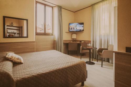 Habitación de hotel con cama y comedor en Hotel Valentino Centro Storico, en Orvieto