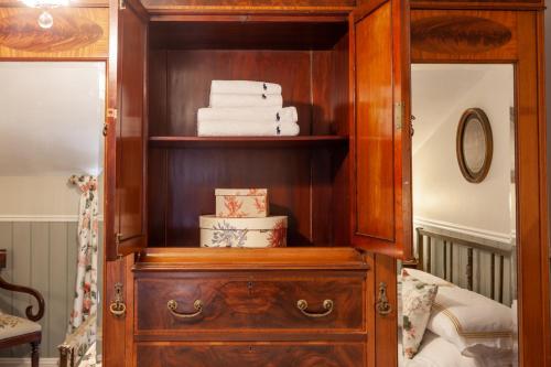 a wooden cabinet with a stack of towels in it at The Georgian - Norfolk Cottage Agency in East Dereham