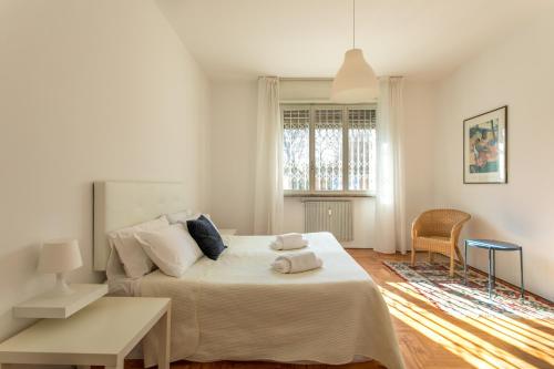 ein weißes Schlafzimmer mit einem großen Bett und einem Tisch in der Unterkunft Cozy Flat Romeo Menti - Vicenza in Vicenza