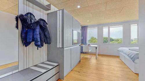 a room with a bedroom with a bed and windows at Evi's Home Hotel & Apartments in Bern