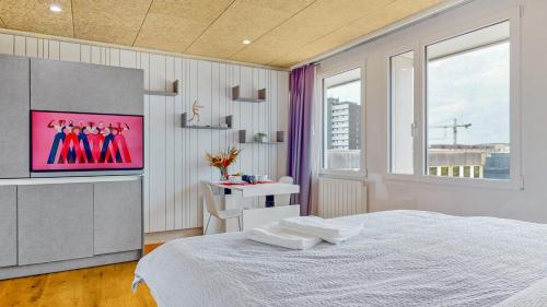 a bedroom with a bed and a tv on the wall at Evi's Home Hotel & Apartments in Bern