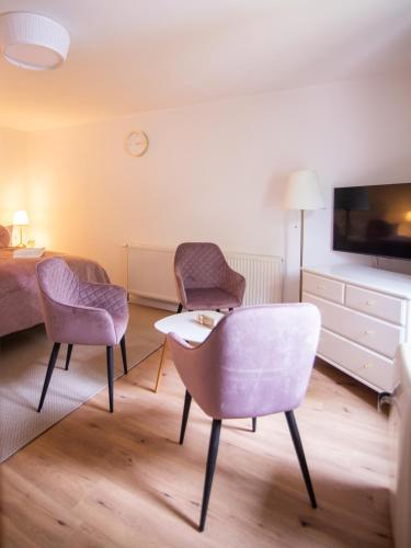 a room with two chairs and a table and a bed at ApartOne Land-Hotel in Sebnitz